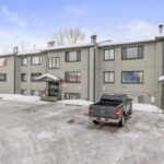 An apartment with snow and vehicles