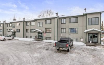 An apartment with snow and vehicles